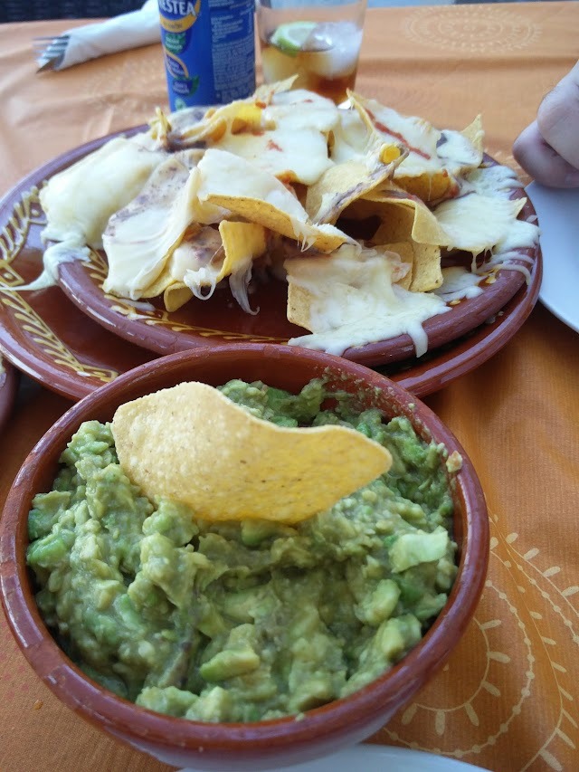 Nachos con queso y cuenco de guacamole recién hecho